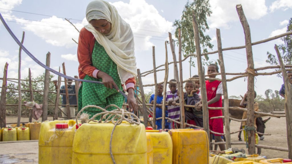 Meheuba Shifa, 23, and a mother of three, fetches water from an IRC rehabilitated water point in the SNNP region of Ethiopia. Before the water point was rehabilitated, Meheuba walk as far as 6 hours one way to gather enough water at for a single day. The daily 12 hour walk meant she was unable to tend to the rest of her family's needs, causing stress in her home. "It was a miserable time, I even lost my donkey with the containers while looking for hours for water once. It was an especially heavy burden on me as none of my children are old enough to help me. When we had no water, I had to do all of my work at night, in the dark, when I would come home very tired. Now, [because the water point has been rehabilitated] I can finish my business during the day. My family is peaceful, and I am happy." Even after gathering water from as far as 6 hours away, the rationed supply -- 40 liters -- was never enough to support her family of five. In order to save water, she would walk two hours away to wash her family's clothes. Woreda: Sankura. ECHO funded.